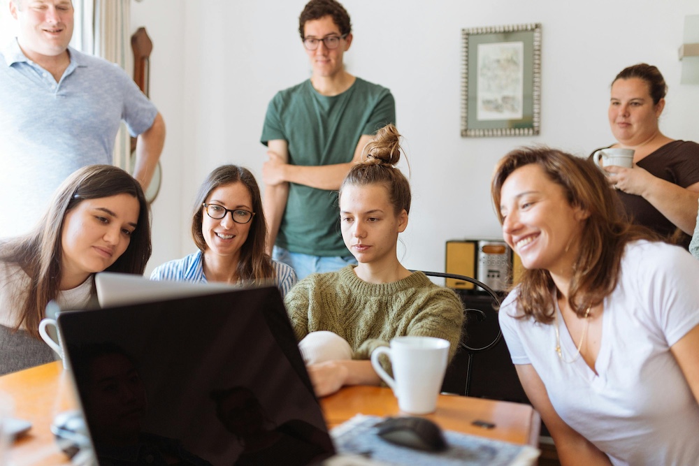 Four people looking at a computer screen.